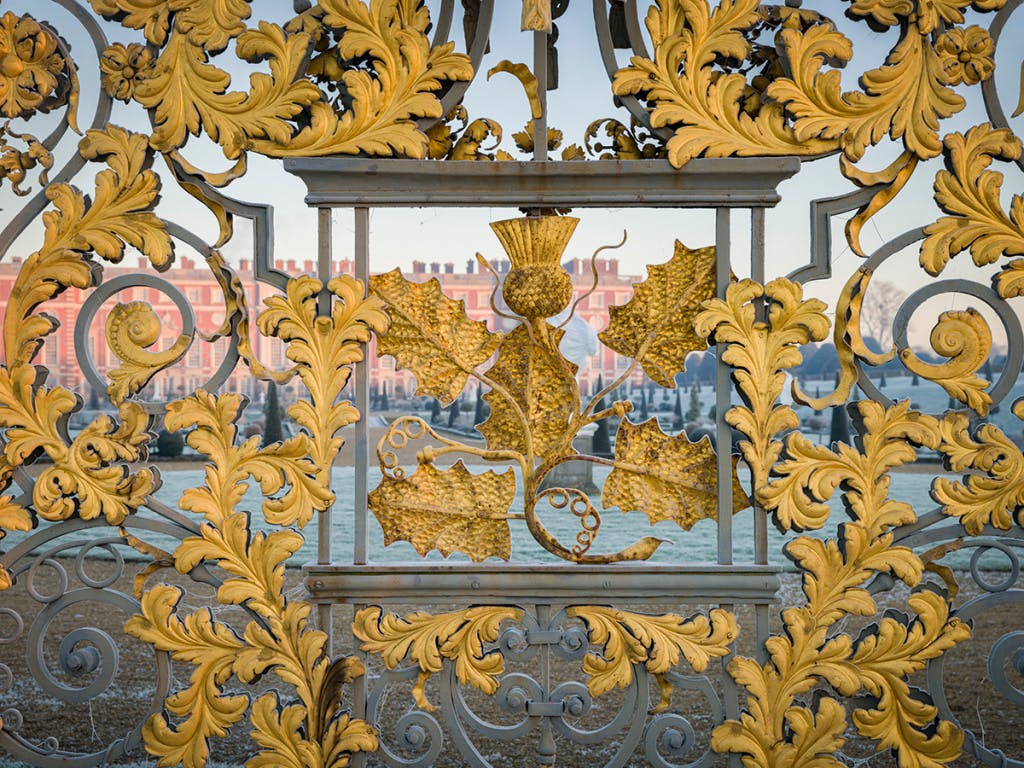 An intricate golden iron panel in a formal garden