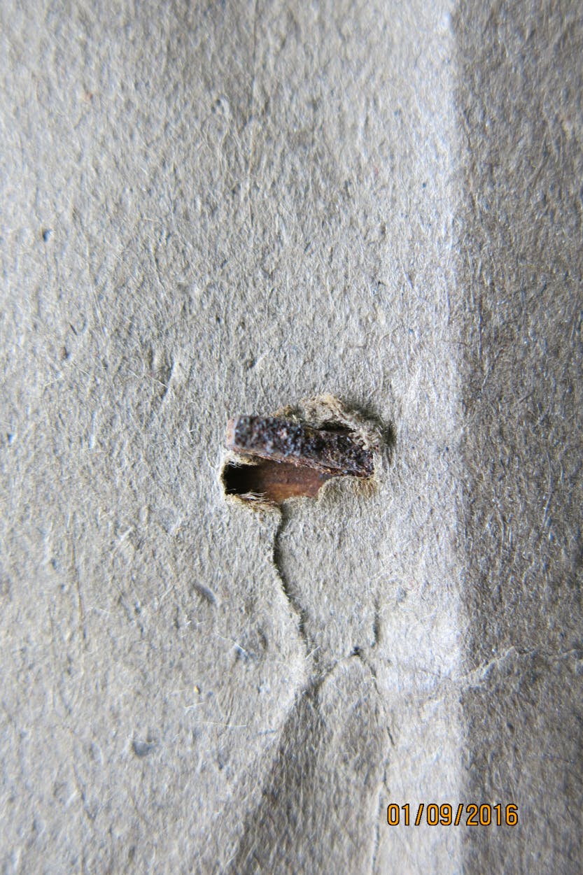 Close up of rusting nail damage at the back of a print.