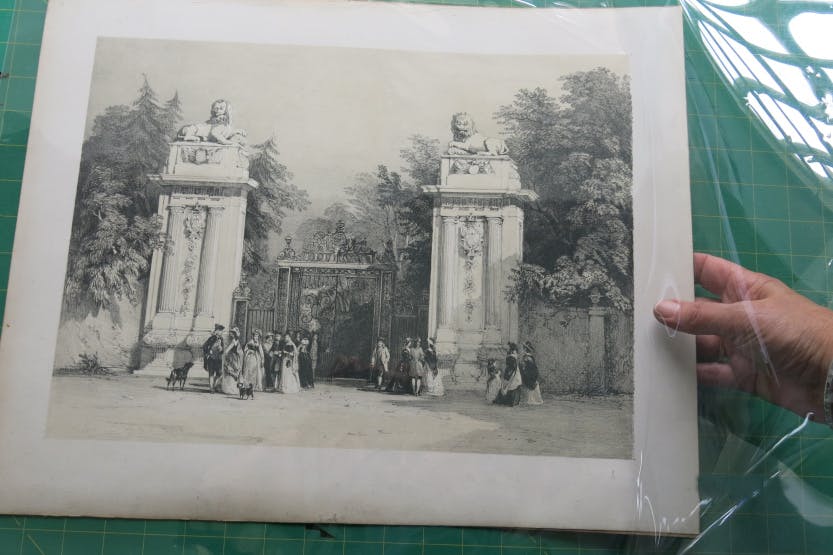 A Conservator's hand storing into a Melines sleeve a sepia coloured lithograph of the Lion’s Gate, created by David Cox Junior c1830.