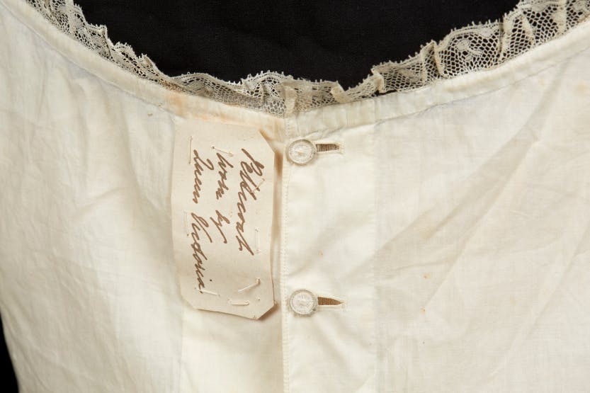 Fine lawn cotton petticoat 1830-45, detail showing a label in a nineteenth-century hand, indicating the petticoat once belonged to Queen Victoria (1837-1901).