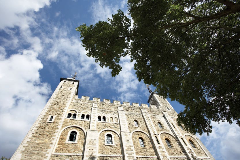 A low angle view of the White Tower looking north, September 2007. Framed against a blue sky with white clouds. A leafy tree overhangs the frame on the right of the image. 

The White Tower was begun in the reign of William the Conqueror (1066-87) and completed by 1100. The fortress was originally faced with huge blocks of pale marble-like Caen stone imported from Normandy. In 1636-8 the external appearance of the White Tower was significantly altered with the replacement of much of its cut-stone work and window surrounds with Portland stone.

The primary role of the White Tower was as a fortress and stronghold but it also served as a royal residence and as the setting for major governmental and ceremonial functions.