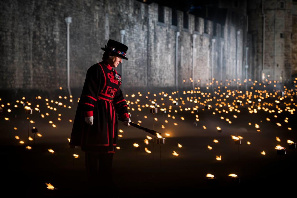The Tower Moat, showing Yeoman Warder Moira Cameron lighting an Armistice torch as part of her ceremonial duty at the "Beyond the Deepening Shadow" public event. 

“Beyond the Deepening Shadow: The Tower Remembers” was a public act of remembrance to commemorate the centenary of the end of the First World War.

Each evening from 4 to 11 November 2018 the Tower moat was illuminated by 10,000 individual flames. The artistic installation included an exploration in sound of wartime alliances, friendship, love and loss. Beginning with a procession led by the Yeoman Warders, Armistice torches were lit to form a circle of light radiating from the Tower. A symbol of remembrance for the hundreds of thousands who died in the Great War.