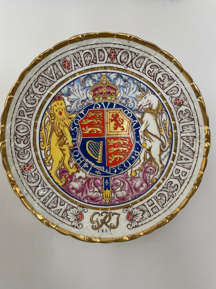 Commemorative plate by Paragon with heraldic designs celebrating the Coronation of King George VI and Queen Elizabeth in 1937. Featuring a yellow lion and white unicorn on either side of a heraldic shield.
