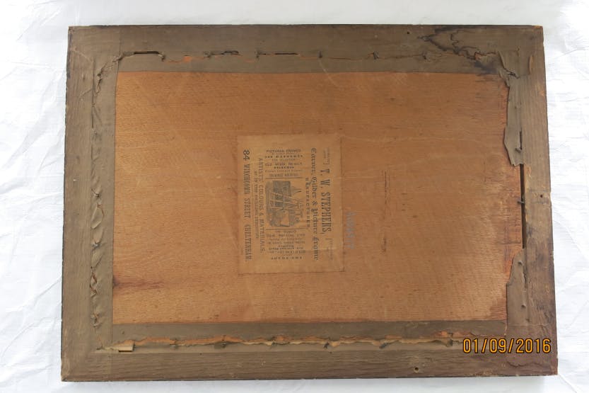 The wooden backing frame on a print, showing the picture frame manufacturer's label "T.W.Stephens" including a drawing of an artist's easel.