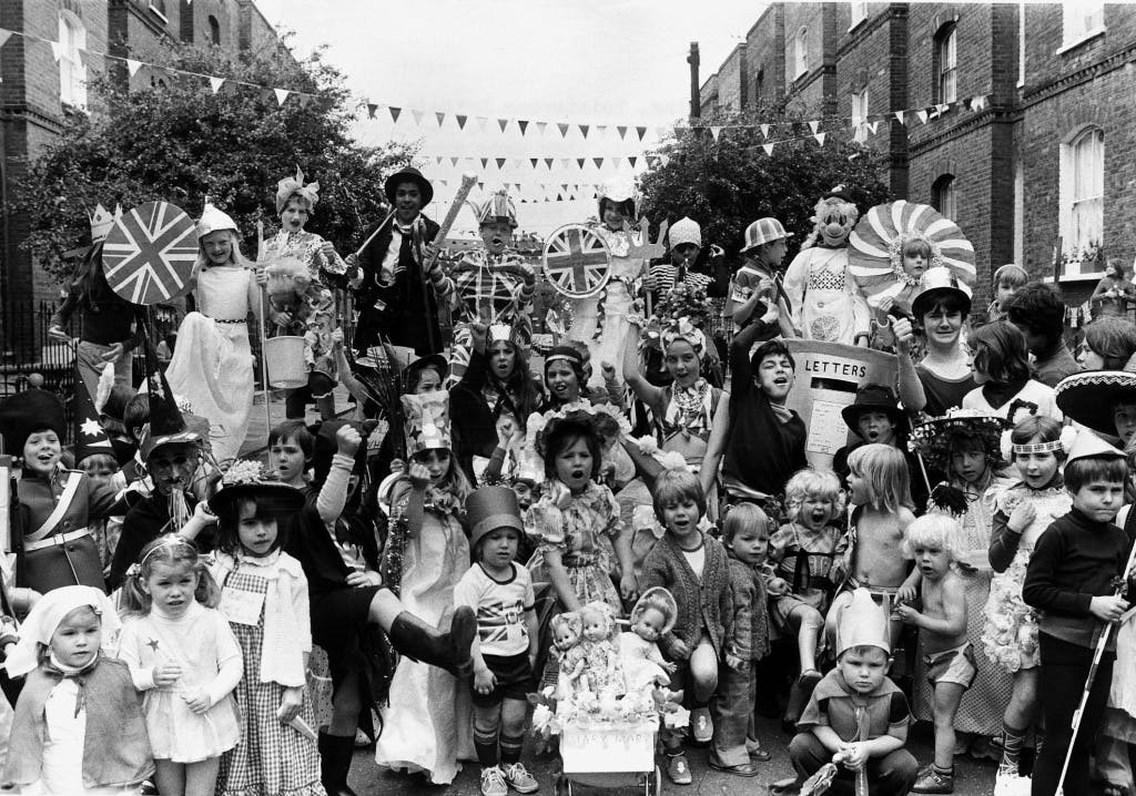 Black and white photograph of a street party with children in fancy dress in Methley Street and Radcot Street in London, celebrating Queen Elizabeth II's 1977 Silver Jubilee