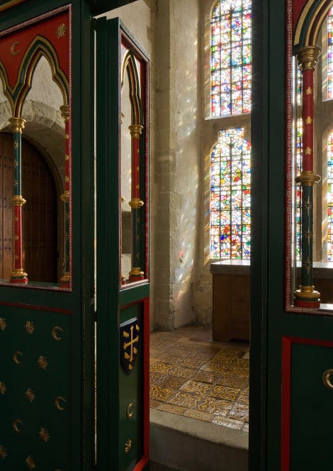 A photograph featuring the painted timber screen and stained-glass window of The King's Private Chapel at The Wakefield Tower Throne Room at the Tower of London.