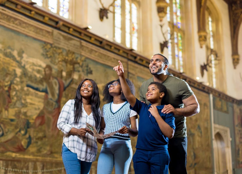 A family visiting Hampton Court Palace in the Great Hall