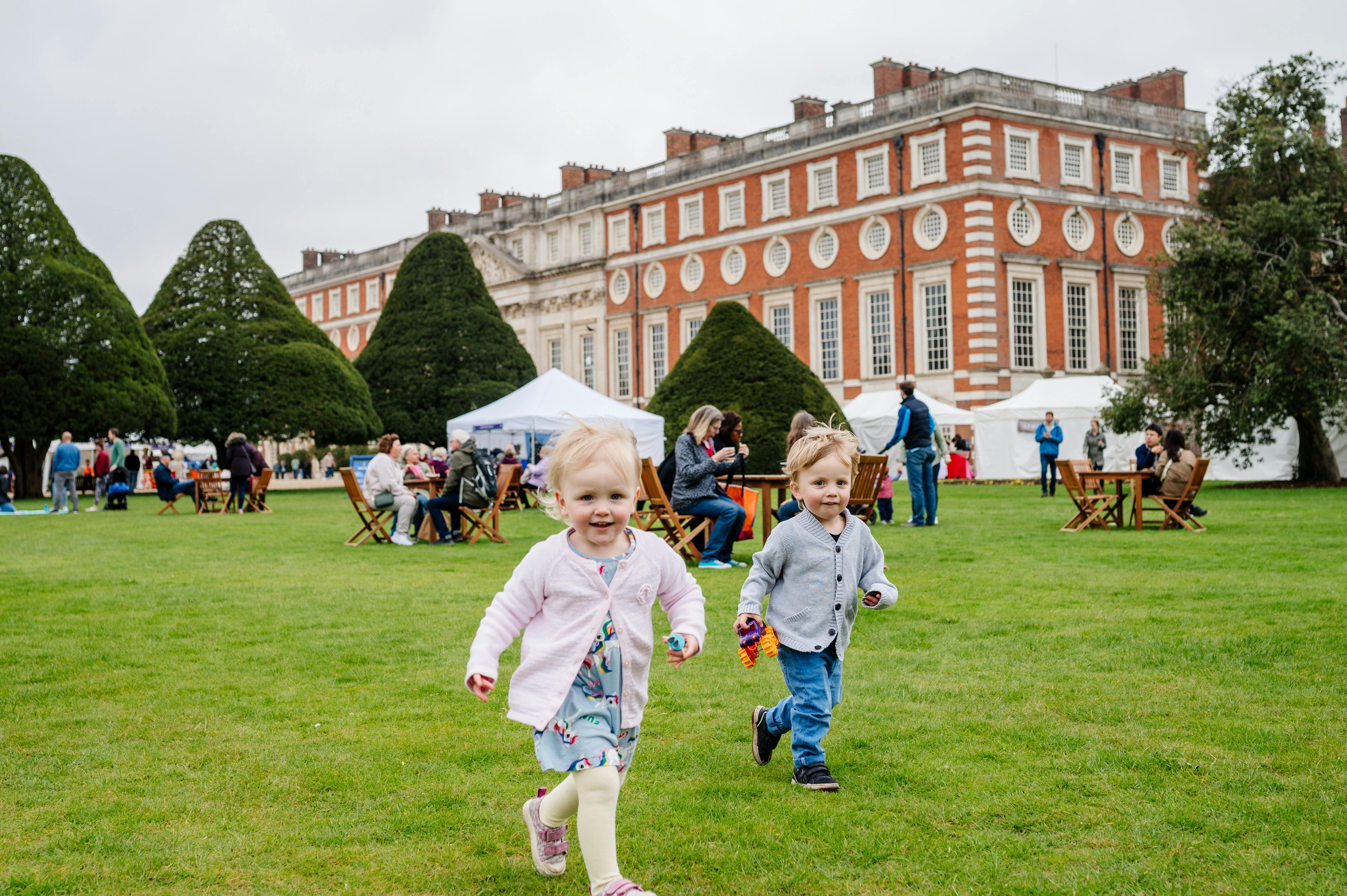 The Great Fountain Garden, showing children running (playing) at Hampton Court Palace's Artisan Fayre, 2023.