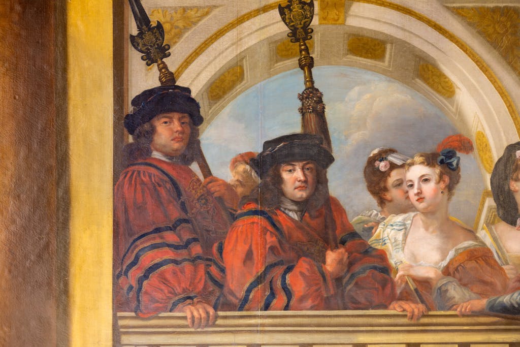 Three figures depicted on a wall painting. Two male figures are dressed in red uniforms with large sleeves, and a female figure is looking at them with a large feather in her hair