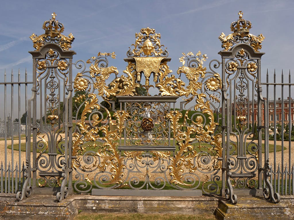 An intricate golden iron panel in a formal garden