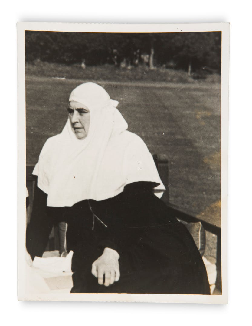 Black and white photograph of Grand Duchess Xenia's (1875-1960) companion, the nun Mother Martha, in the garden at Wilderness House.

Grand Duchess Xenia Romanov was the sister of the last Tsar of Russia, Nicholas II. After the fall of the Russian monarchy in February 1917 she fled her home country to settle in the United Kingdom. She was a grace-and-favour resident in Wilderness House at Hampton Court Palace from 1937 until her death in 1960.