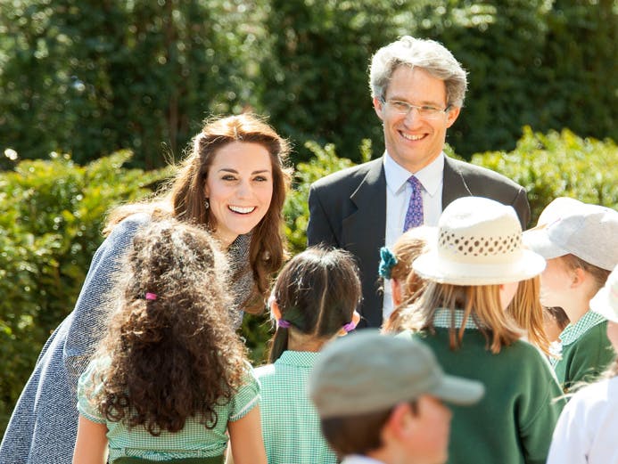 The Magic Garden, showing Her Royal Highness the Duchess of Cambridge smiling at a group of children watched by Rupert Gavin (Historic Royal Palaces Chairman of Board of Trustees) and one other.