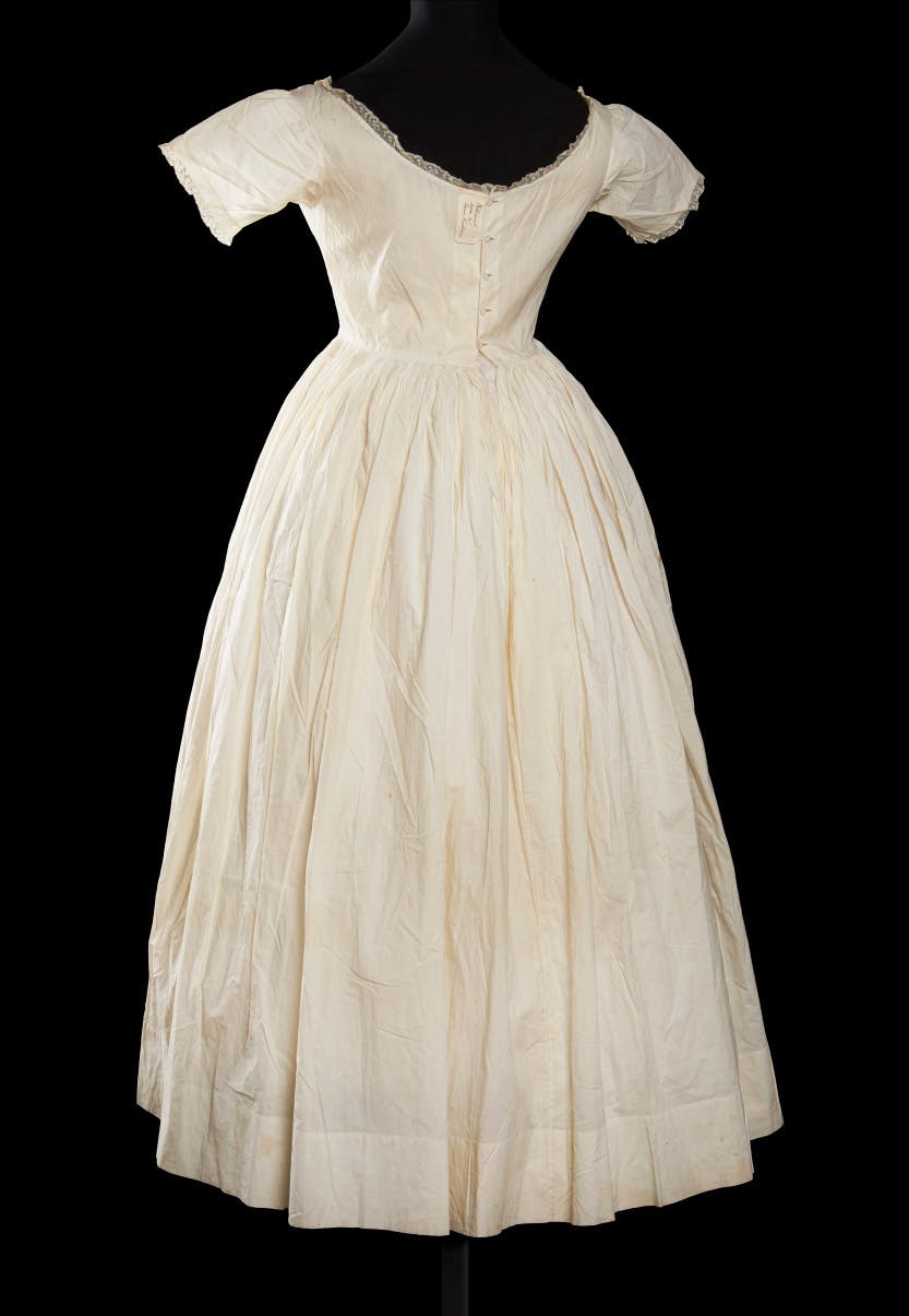 Fine lawn cotton petticoat 1830-45, trimmed with lace. Worn by Queen Victoria (1837-1901). Photographed against a black background.