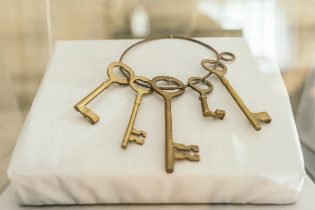 A set of gold keys on a white pillow