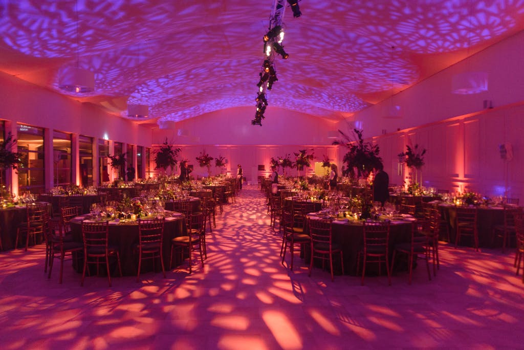 The Pavilion set up with round tables for dinner with a ceiling and floor wash.
