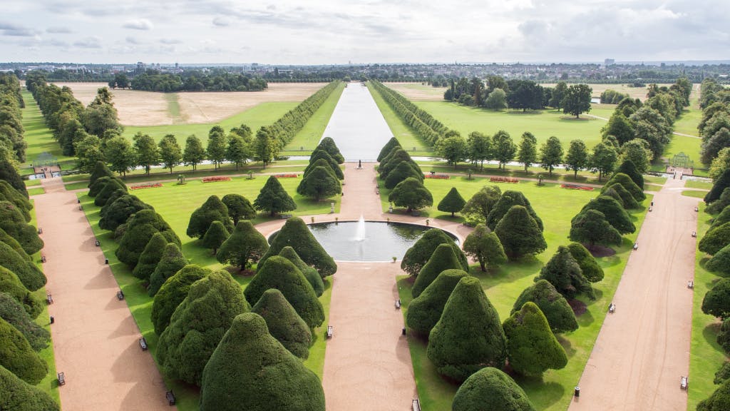 The Great Fountain Garden. Aerial view looking east showing the central pond and avenues of yew trees. In the distance is the Long Water in Home Park.